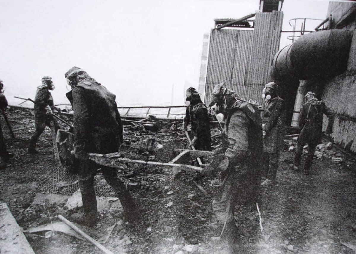 Incident responders in respirators clearing radioactive debris from the roof of Chernobyl reactor 3, 1986